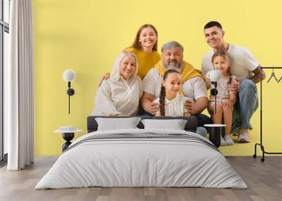 Big family sitting on yellow background Wall mural