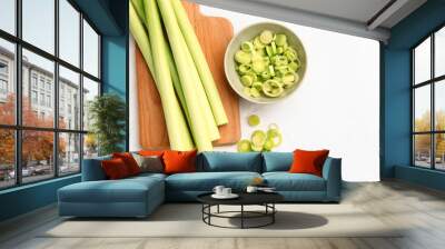 Board and bowl with slices of fresh leek on white background Wall mural