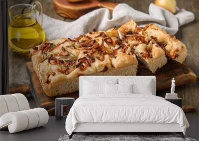 Board of tasty Italian focaccia with roasted onion on wooden table, closeup Wall mural