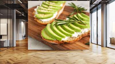 Board with delicious avocado toasts and rosemary on grey background Wall mural