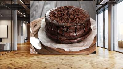 Board with delicious chocolate cake on wooden table Wall mural