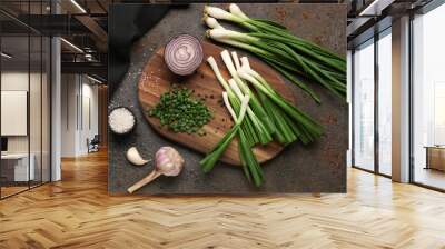 Board with slices of fresh scallion and onion on dark background Wall mural