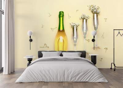 Bottle of champagne, glasses and flowers on color background Wall mural