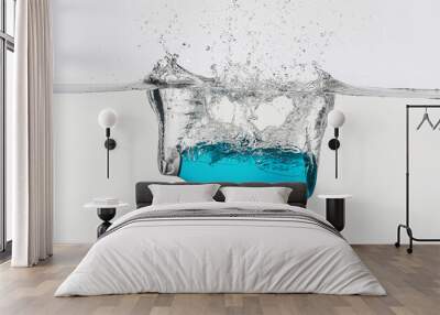 Bottle of cosmetic product in water with splashes on white background Wall mural