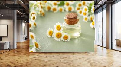 Bottle of essential oil with chamomile flowers on wooden table Wall mural