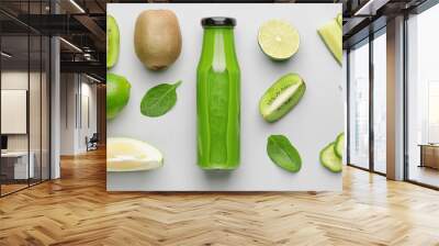 Bottle of healthy green smoothie and ingredients on light background, top view Wall mural