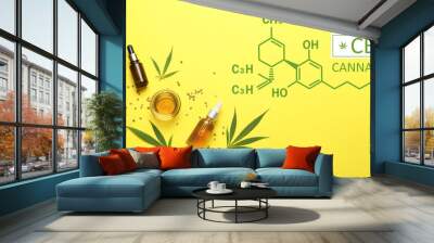 Bottles and bowl of CBD oil on yellow background Wall mural