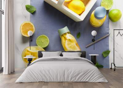 Bottles and jug of infused water with lemon on white marble background Wall mural