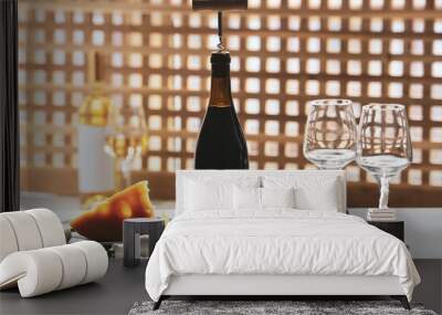 Bottles of exquisite wine, glasses, cheese and corkscrew on light table in room Wall mural