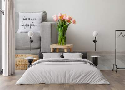 Bouquet of tulip flowers on table near light wall in room Wall mural