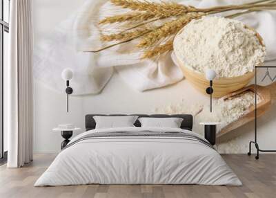 bowl and scoop with wheat flour on white table Wall mural