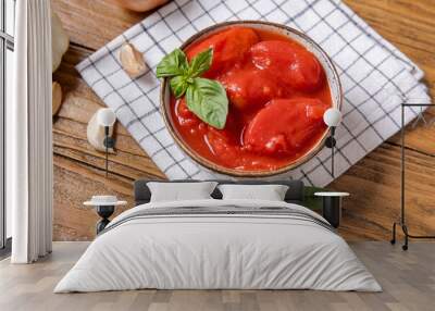 Bowl of tasty canned tomatoes and napkin on wooden background Wall mural