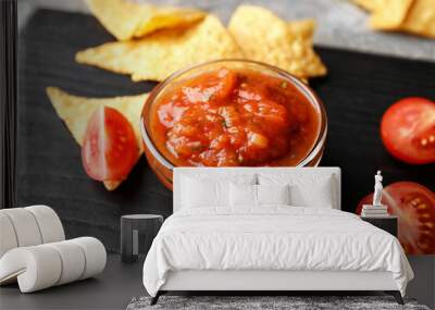 Bowl of tasty salsa sauce with nachos on dark wooden background Wall mural