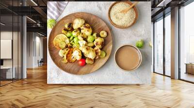 Bowl of tasty tahini and grilled vegetables on table Wall mural