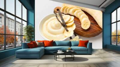 Bowl of tasty vanilla pudding and banana on white background, closeup Wall mural