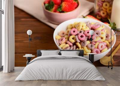 Bowl with colorful sweet cereal rings and strawberries on wooden background Wall mural