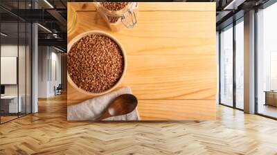 Bowl with dry buckwheat grains on wooden table Wall mural