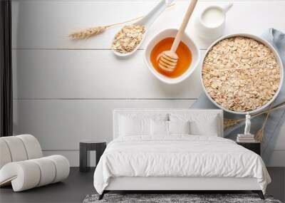 Bowl with raw oatmeal, honey and milk on white wooden table Wall mural