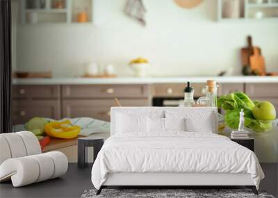 Bowl with salad and ingredients on kitchen table Wall mural