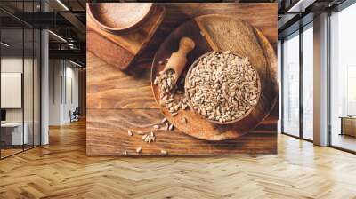 Bowl with sunflower seeds on wooden background Wall mural