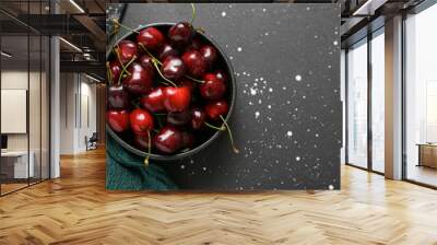 Bowl with sweet cherries on black background Wall mural