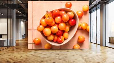 Bowl with sweet yellow cherries on pink tile background Wall mural