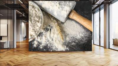 Bowl with wheat flour and rolling pin on dark table, closeup Wall mural