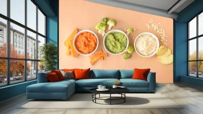 Bowls with healthy baby food on color background Wall mural