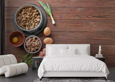 Bowls with pet food and natural products on wooden background Wall mural