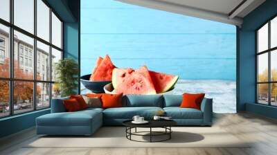 Bowls with pieces of fresh watermelon on blue table Wall mural