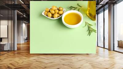 Bowls with ripe olives and oil on green background Wall mural