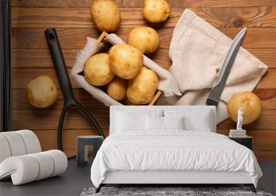 Box with raw potatoes on wooden background Wall mural