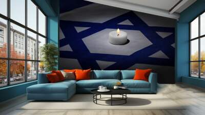 Burning candle on flag of Israel. International Holocaust Remembrance Day Wall mural