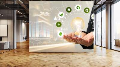 Businesswoman using virtual screen with light bulb and different icons. Green technology concept Wall mural