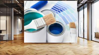 Cans of paint with brush on table, closeup Wall mural