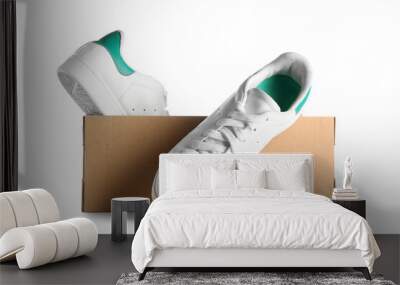 Cardboard box with sneakers on white background Wall mural