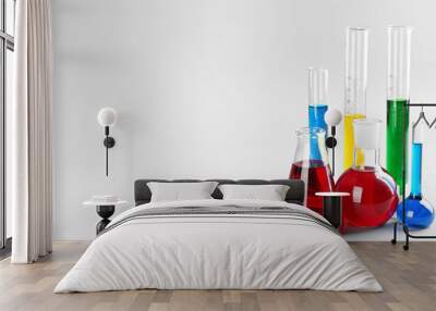 Chemical glassware with colorful liquids on light background Wall mural