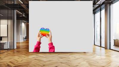 Child with pop it fidget toy on light background Wall mural