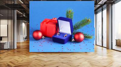 Christmas gift box with stylish earrings in shape of candy canes and decorations on blue background Wall mural