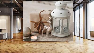 Christmas lantern with burning candles, gift and decor on floor in room Wall mural