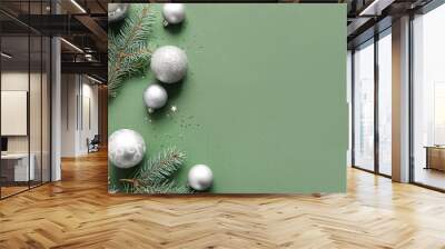 Christmas tree branches with balls on green background Wall mural