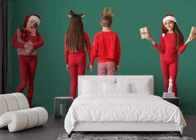 Collage of cute little children in pajamas and with Christmas gifts on green background Wall mural