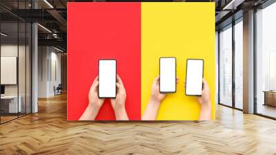 Collage of hands with modern mobile phones on color background Wall mural