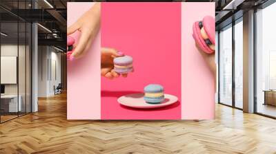 Collage of hands with tasty macarons on pink background Wall mural