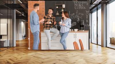 Colleagues drinking coffee in kitchen of office Wall mural