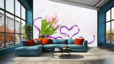 Composition with bouquet of beautiful tulip flowers and ribbon in shape of heart on light background. Women's Day celebration Wall mural