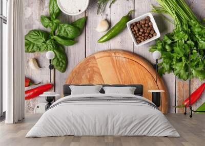 Composition with cutting board, fresh herbs and spices on light wooden background Wall mural