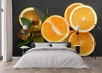 Composition with orange essential oil on dark background Wall mural