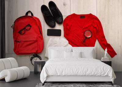 Composition with stylish school uniform, backpack, eyeglasses, alarm clock and mobile phone on wooden background Wall mural