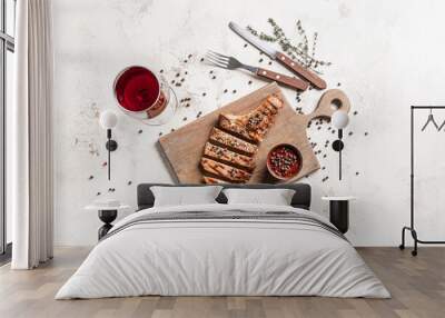 Composition with tasty roasted meat, peppercorn sauce and glass of wine on light background Wall mural